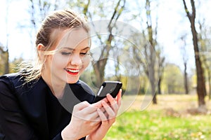 Woman with unkempt hair looking into smartphone smiling