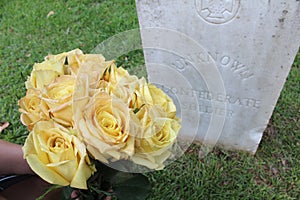 Woman at Unknown soldier`s grave with yellow flowers.