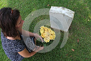 Woman at Unknown soldier`s grave with yellow flowers.