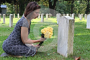 Woman at Unknown soldier`s grave with yellow flowers.