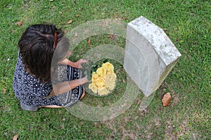 Woman at Unknown soldier`s grave with yellow flowers.