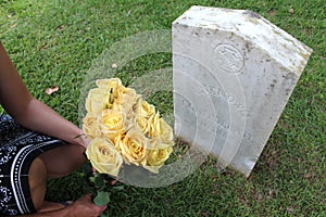 Woman at Unknown soldier`s grave with yellow flowers.