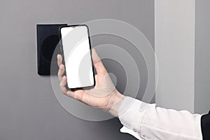 Woman unlocking door using smartphone, closeup view