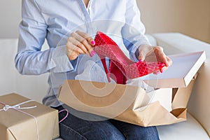 Woman unpacking new shoes delivered by post