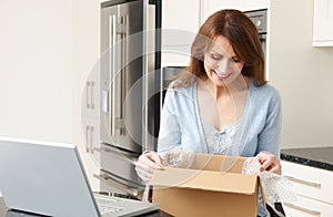 Woman Unpacking Online Purchase At Home