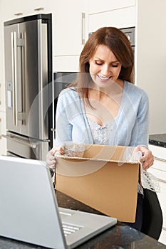 Woman Unpacking Online Purchase At Home