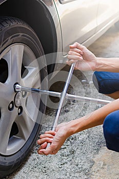 Woman are unscrew power to change tire by two hands photo
