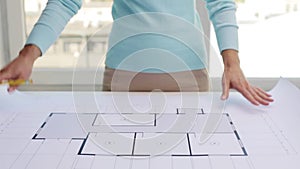 Woman unwrapping architectural blueprint
