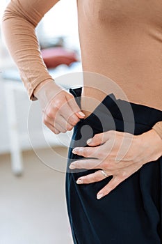 Woman unzips trousers