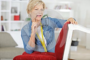 Woman upholstering chair in workshop