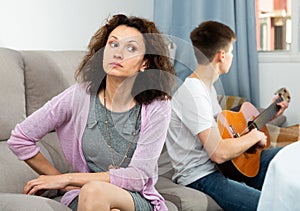 Woman upset because of son playing guitar