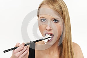 A woman use chopsticks eating Rice