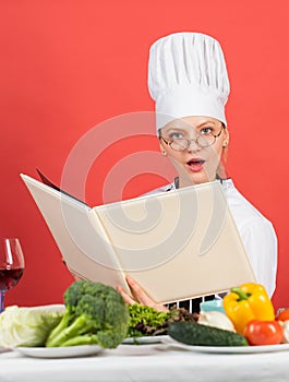 Woman use Cookbook. professional chef read recipe for cooking. female chef preparing dish. cook in her kitchen. Open