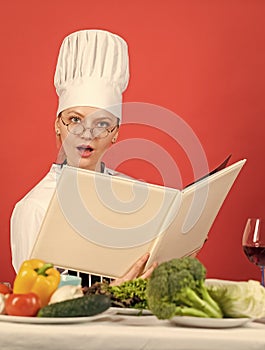 woman use Cookbook. professional chef read recipe for cooking. female chef preparing dish. cook in her kitchen. Open