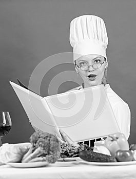 woman use Cookbook. professional chef read recipe for cooking. female chef preparing dish. cook in her kitchen. Open
