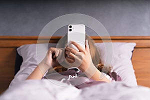 Woman use phone on bed after wake up