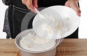 Woman use rice spoon to scoop rice from pot