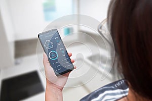 Woman use smart home control app on modern mobile phone