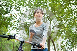 Woman use of the smart phone and riding a bike