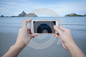 Woman use smart phone take a photo of the sea in PrachuapkhirikhWoman use smart phone take a photo of the sea in