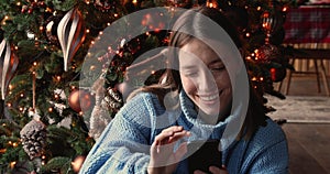 Woman use smartphone chatting with friends remotely on Christmas Eve