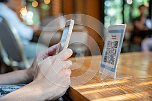 woman use smartphone to scan QR code to pay in cafe restaurant with a digital payment without cash. Choose menu and order