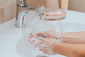 Woman use soap and washing hands under the water tap. Hygiene concept hand detail