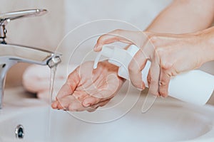 Woman use soap and washing hands under the water tap. Hygiene concept hand detail