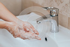 Woman use soap and washing hands under the water tap. Hygiene concept hand detail