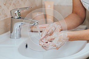 Woman use soap and washing hands under the water tap. Hygiene concept hand detail