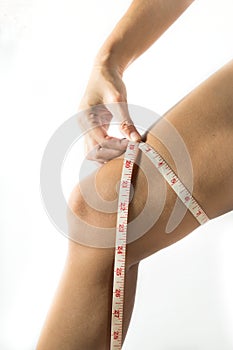 Woman use tape measure with leg.