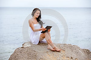 Woman use touch pad tablet pc internet technology sitting beach