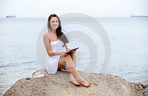 Woman use touch pad tablet pc internet technology sitting beach