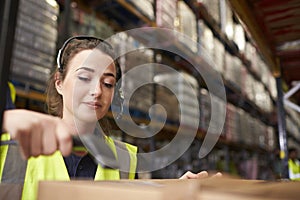 Woman uses barcode reader in a warehouse, head and shoulders photo