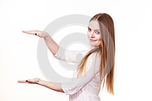 Woman uses hands to indicate area of frame, copy space for product