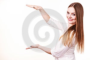 Woman uses hands to indicate area of frame, copy space for product