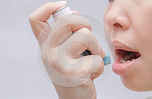 Woman uses an inhaler during an asthma attack