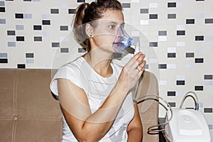 Woman uses an inhaler at home when she coughs. Treatment of respiratory diseases. Inhalation with bronchitis.