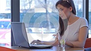 Woman uses laptop touchpad at the cafe