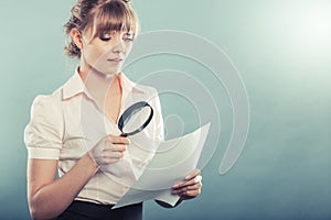 Woman uses magnifying glass to check contract