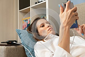 Woman uses a mobile phone, a smartphone, charged from the power bank