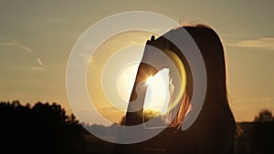 Woman uses a virtual reality glasses in the forest at sunset