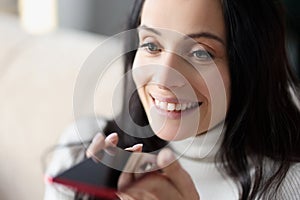 Woman uses voice dialing in smartphone closeup