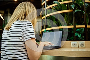 Woman usinf laptop in cafe. Freelancer in coworking