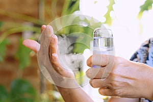 Woman using alcohol nano mist sprayer antiseptic cleaning on her hands protection during Coronavirus pandemic Covid-19.Hand using photo