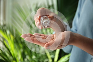 Woman using antibacterial hand gel, closeup photo