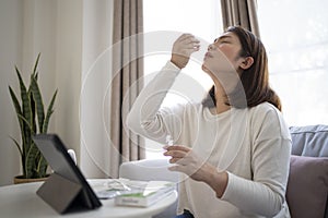 Woman using antigen test kit for testing COVID-19 test with ATK at home