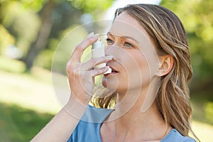 Žena astma inhalátor v parku 