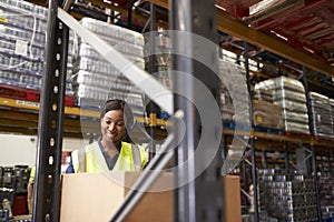 Woman using barcode reader in warehouse, head and shoulders