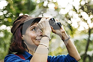 Woman using binoculars while trekking